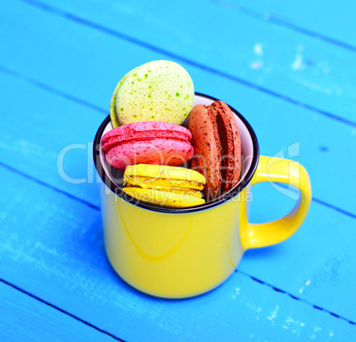 macarons in a yellow ceramic cup