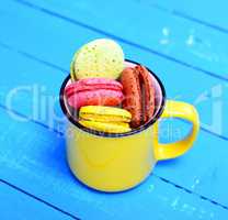 macarons in a yellow ceramic cup