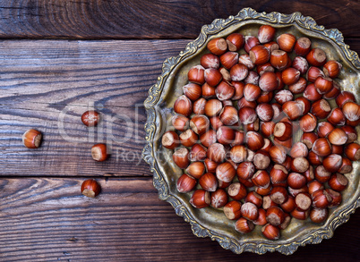 Hazelnut nut in shell on an iron copper plate