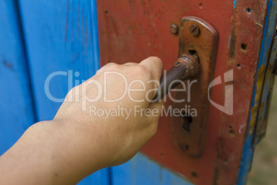 Woman hand open old wooden door