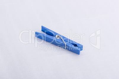 A blue cloth pin on a white surface