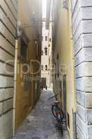 bicycle leaned on a wall of a narrow alley