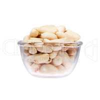 Glass saucepan with peanuts, isolated on white background.