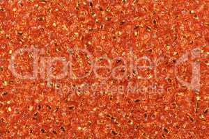 Multicolored orange seed beads background.