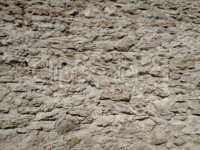 A solid wall with a stone on a summer day .