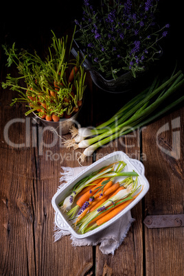 Young carrots and spring onions prepared for baking