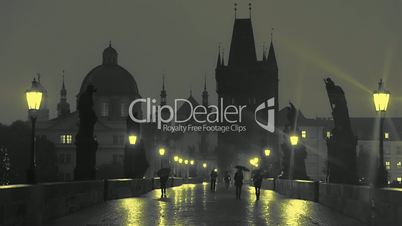 Pedestrians with Umbrellas on the Charles Bridge at Night. Slow Motion
