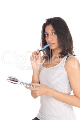 Woman standing with pen in her mouth.