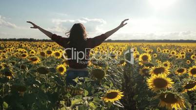 Carefree happy woman running in sunflower field