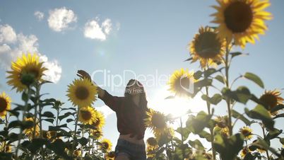 Cheerful woman walking in field of sunflowers