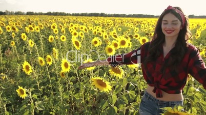 Sensual brunette girl walking in sunflower field