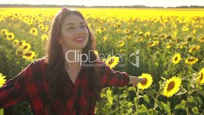 Happy woman walking in fresh sunflower field