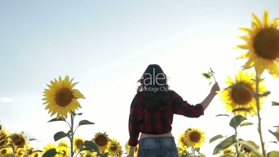 Happy elegant woman running in sunflower field