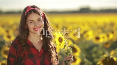 Sensual smiling woman posing in sunflower field