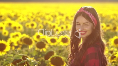 Beautiful brunette girl smiling in sunflower field