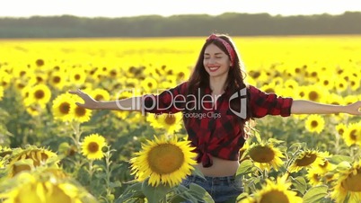 Joyful woman spinning around in sunflower field