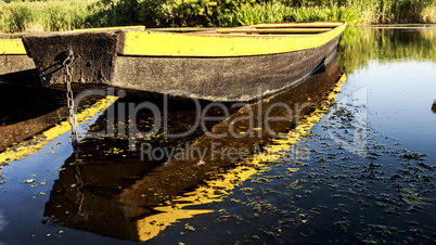 Row boat floating on the lake and reflects in it