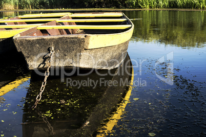 Row boat floating on the lake and reflects in it