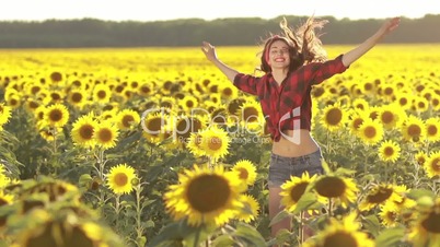 Emotional charming girl jumping in sunflower field