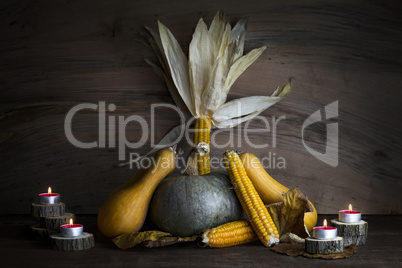 Pumpkin, Corncob, autumn leaves and burning candles Decoration o