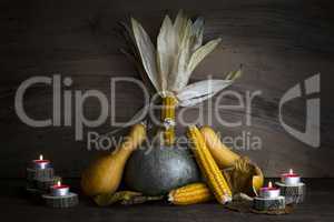 Pumpkin, Corncob, autumn leaves and burning candles Decoration o