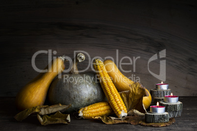 Pumpkin, Corncob, autumn leaves and burning candles Decoration o