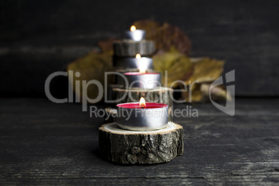 Christmas candles burning, decoration with wooden logs resting o