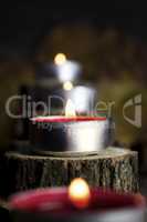 Christmas candles burning, decoration with wooden logs resting o