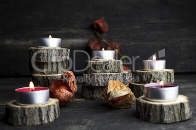 Christmas candles burning, decoration with wooden logs resting o