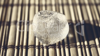 Ice cube on the wooden surface