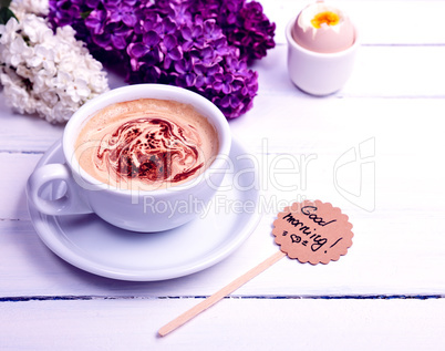 Cup with cappuccino on a white wooden background