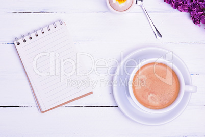 Empty paper notebook and cup of coffee