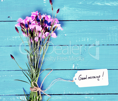 bouquet of pink carnations and a paper tag