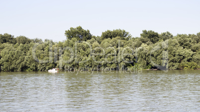 Danube River with Fishing Boat And Treeline in the Background
