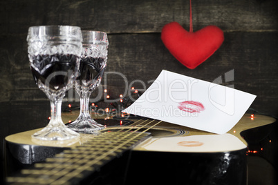 Kiss On White Paper Resting on Acoustic Guitar With Vine Glasses