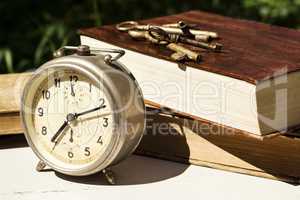 Vintage still life with old alarm clock, keys and books