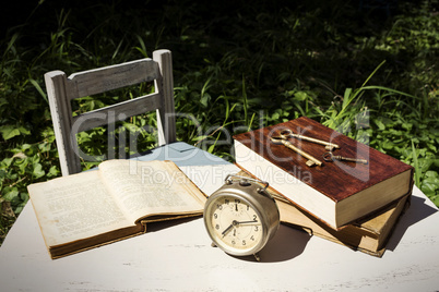 Vintage still life with old alarm clock, keys and books