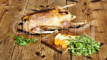 Roasted goose on wooden table