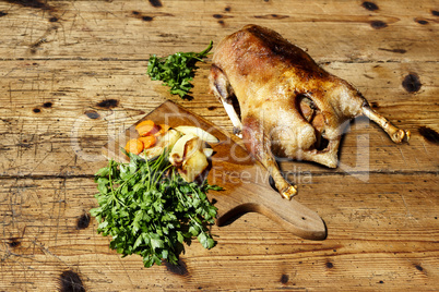 Roasted goose on wooden table