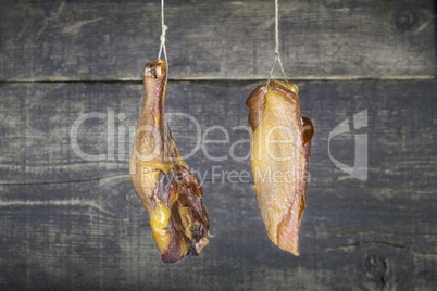 Smoked Chicken Meat Hanging on the Rope Against Wooden Backgroun