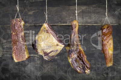 Smoked Meat Hanging on the Rope Against Wooden Background With S