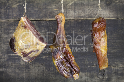 Smoked Meat Hanging on the Rope Against Wooden Background