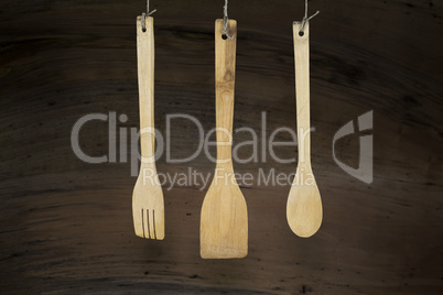 Kitchen Utensils Hanging On A Rope Against Rustic Wooden Backgro