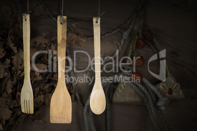 Kitchen Utensils Hanging On A Rope Against Rustic Wooden Backgro