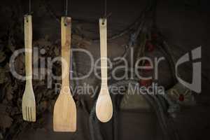 Kitchen Utensils Hanging On A Rope Against Rustic Wooden Backgro