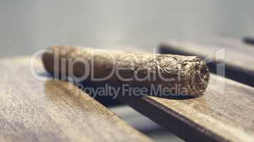 Cuban cigar resting on a wooden surface