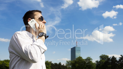 Successful Businessman Talking On The Phone In The Park With Cor