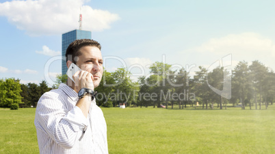 Successful Businessman Talking On The Phone In The Park With Cor