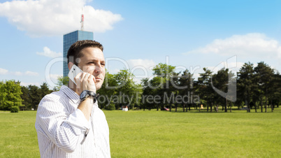 Successful Businessman Talking On The Phone In The Park With Cor