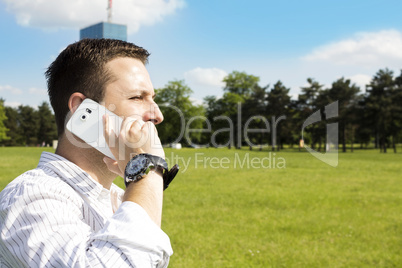 Successful Businessman Talking On The Phone In The Park With Cor